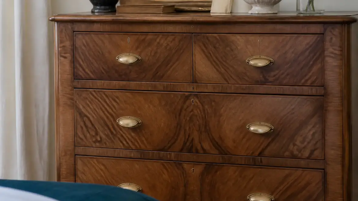 Façade de commode en noyer massif aux veines brunes et sombres, avec un dessin flammé au centre du panneau