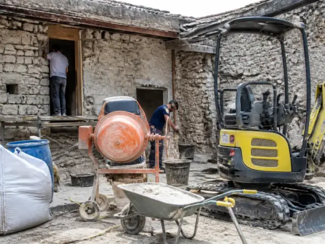 Chantier avec pelle mécanique, bétonnière et ouvrier utilisant l'équipement de proxichantier.fr