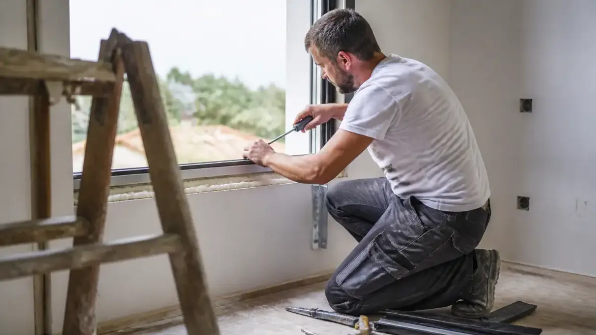 Homme installant une fenêtre lors d'un chantier avec proxichantier.fr pour l'installation facile
