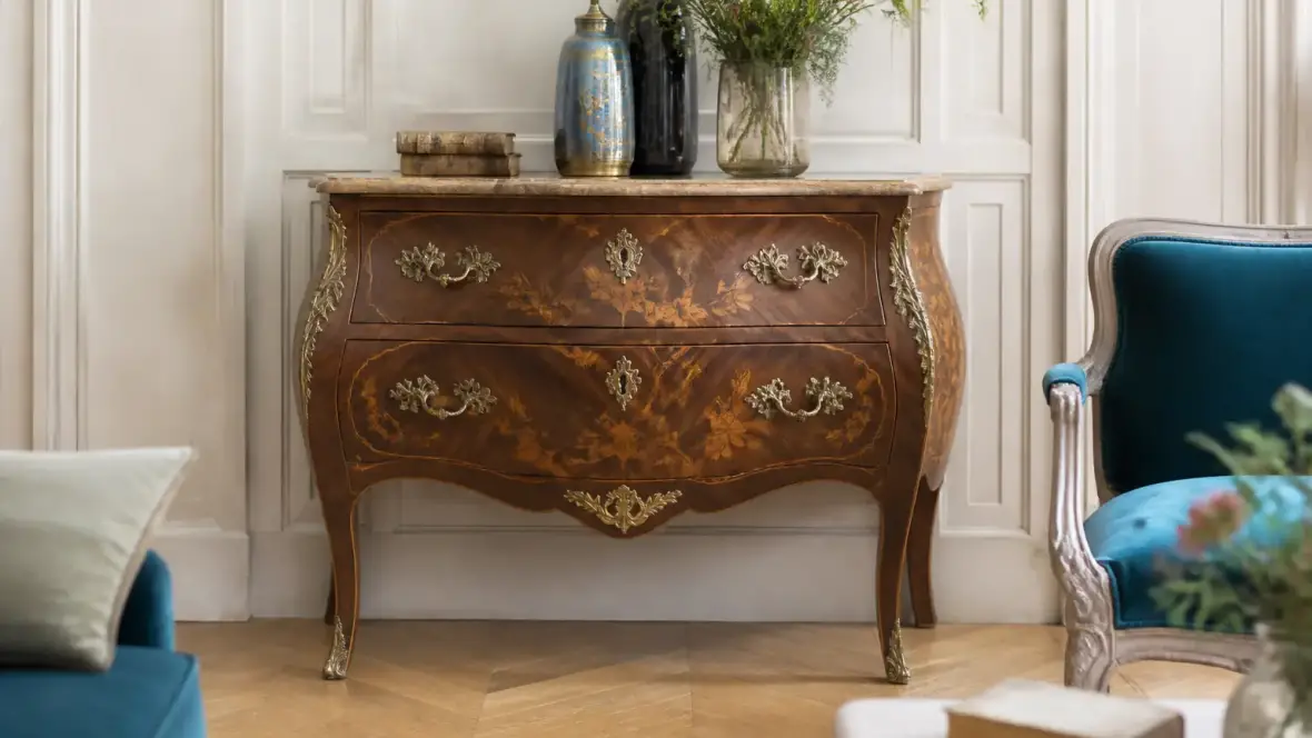 Commode ancienne à façade galbée et pieds cambrés, ornée de bronzes dorés en forme de coquilles et de feuillages